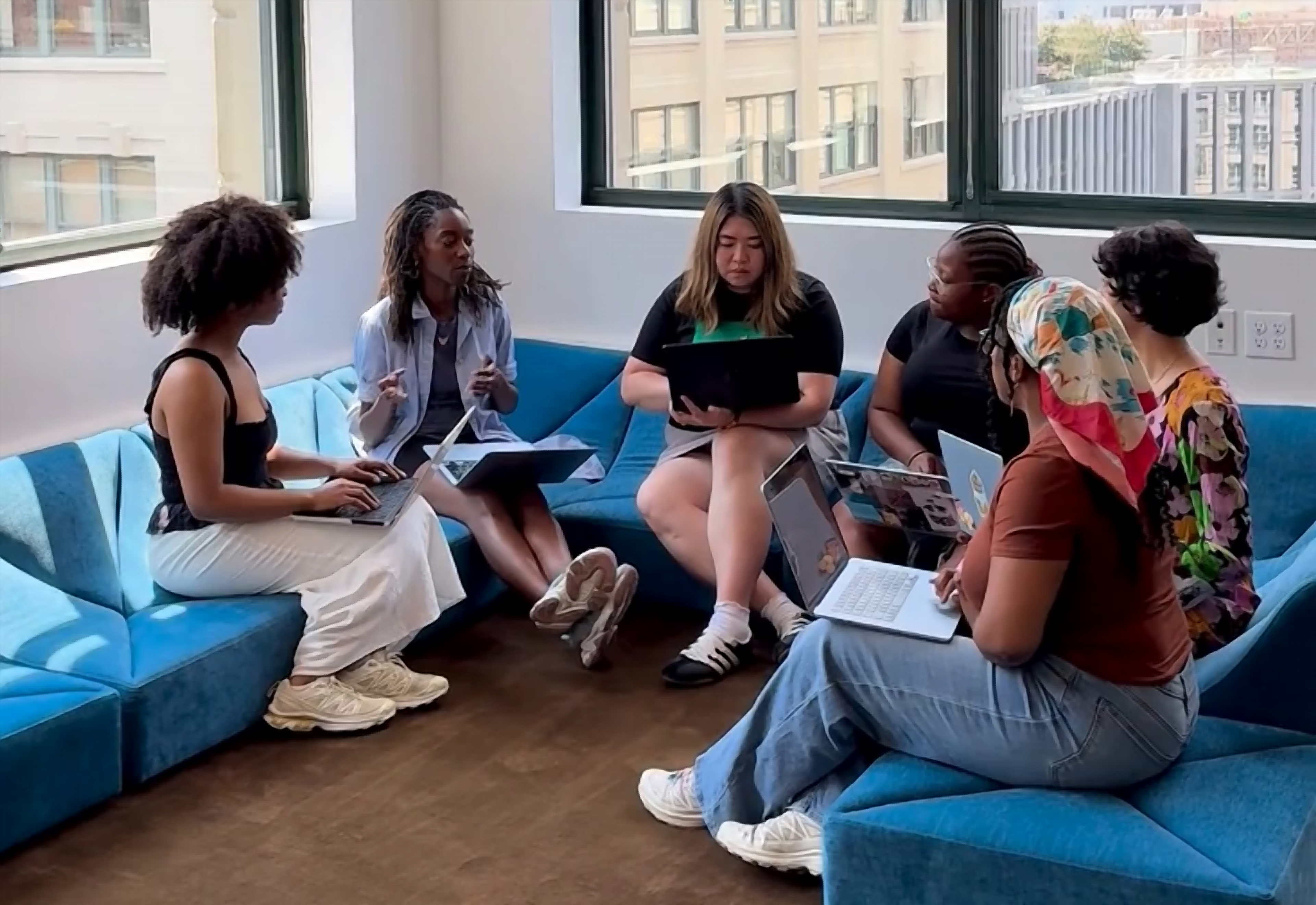 The Renatural team meeting on couches at corner office