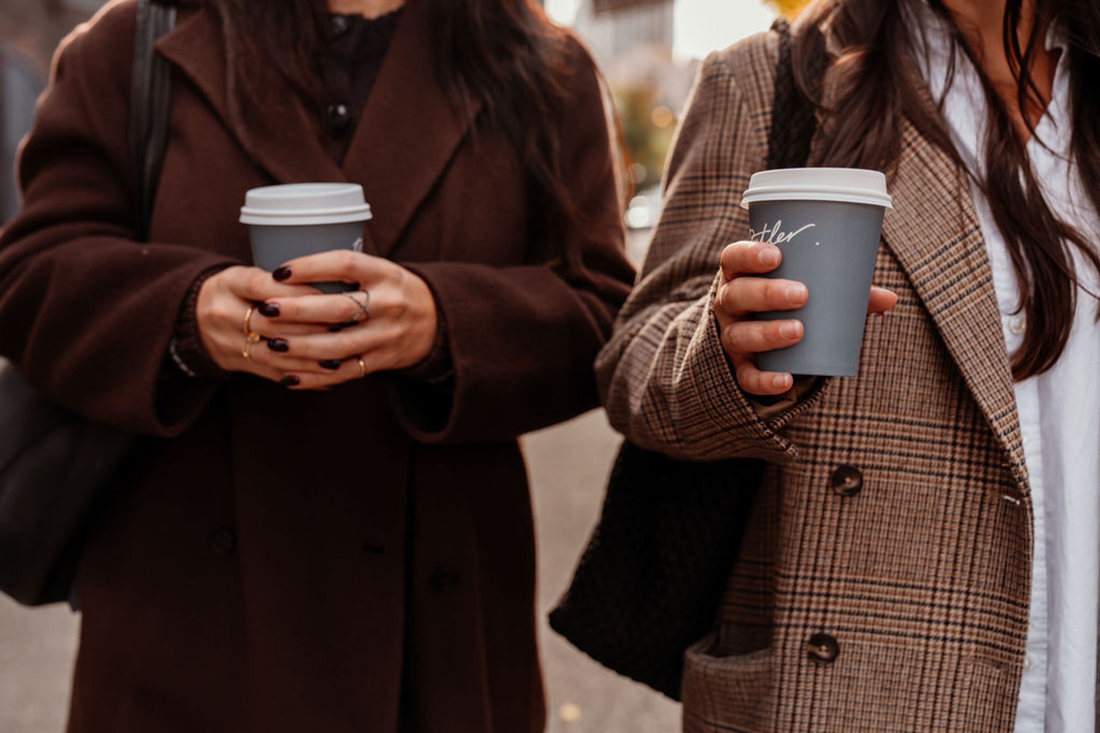 Two women walking with coffee