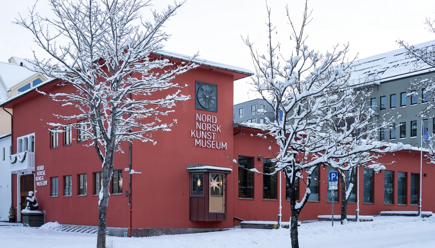 Museumsbygg med rød fasade i snødekkede omgivelser