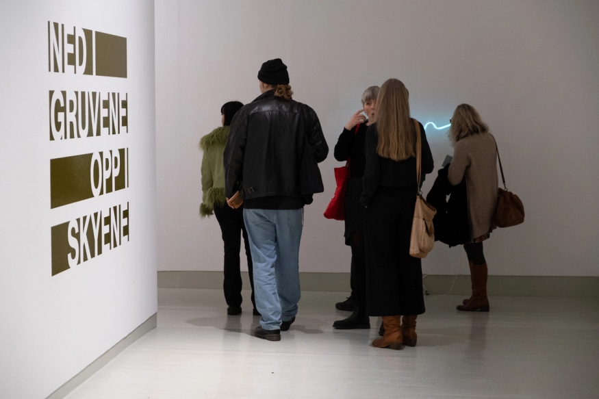 En gruppe mennesker går inn i et galleri. 