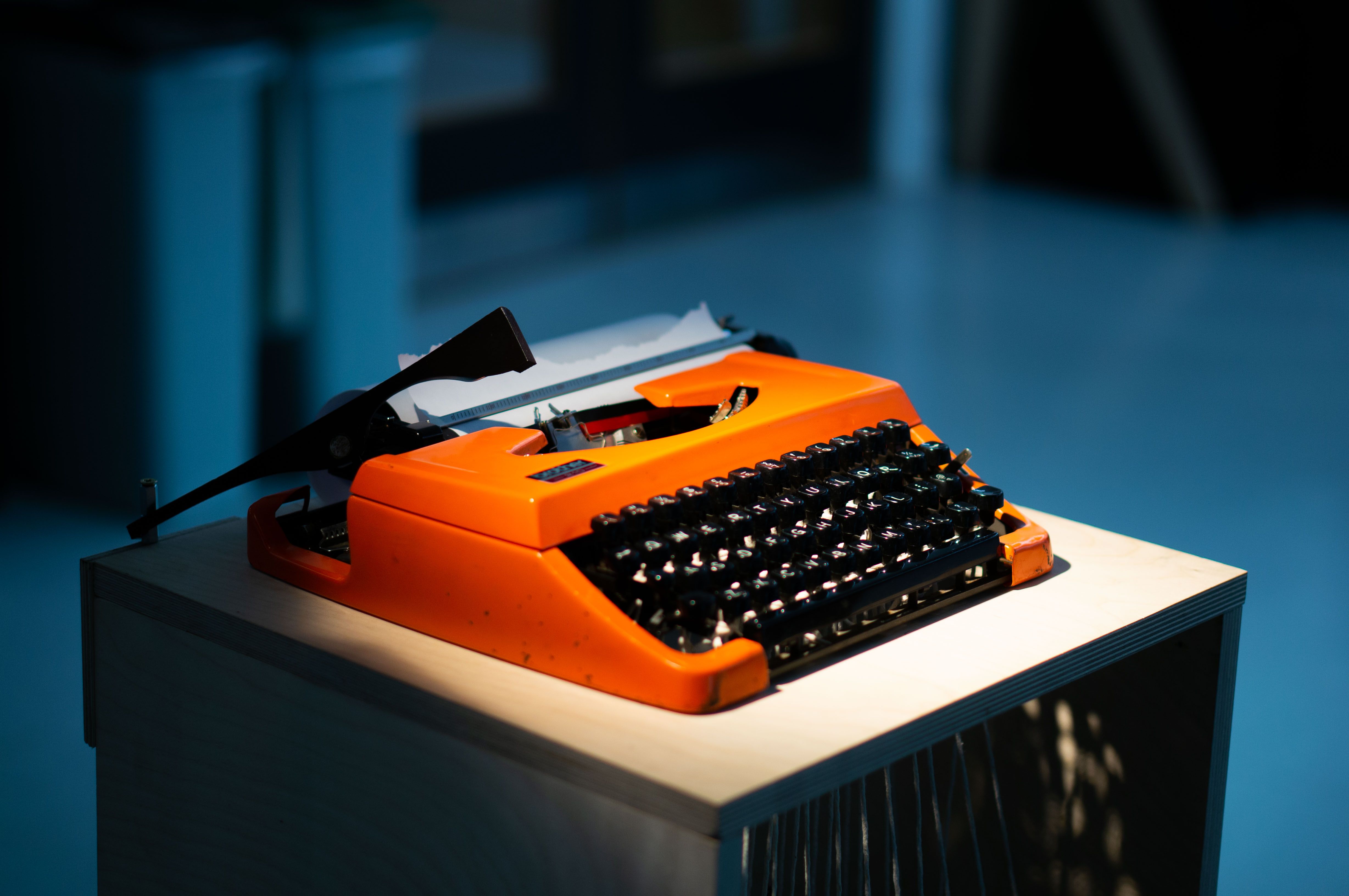 orange typewriter, dramatically lit, at an angle