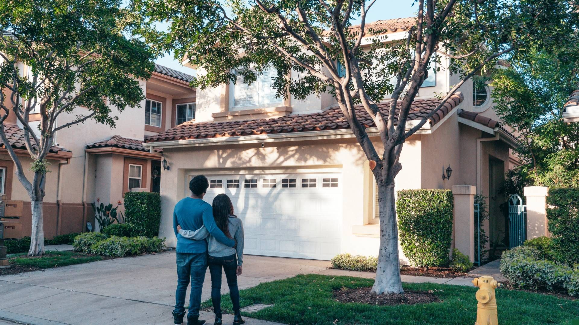 couple standing in front of home to buy