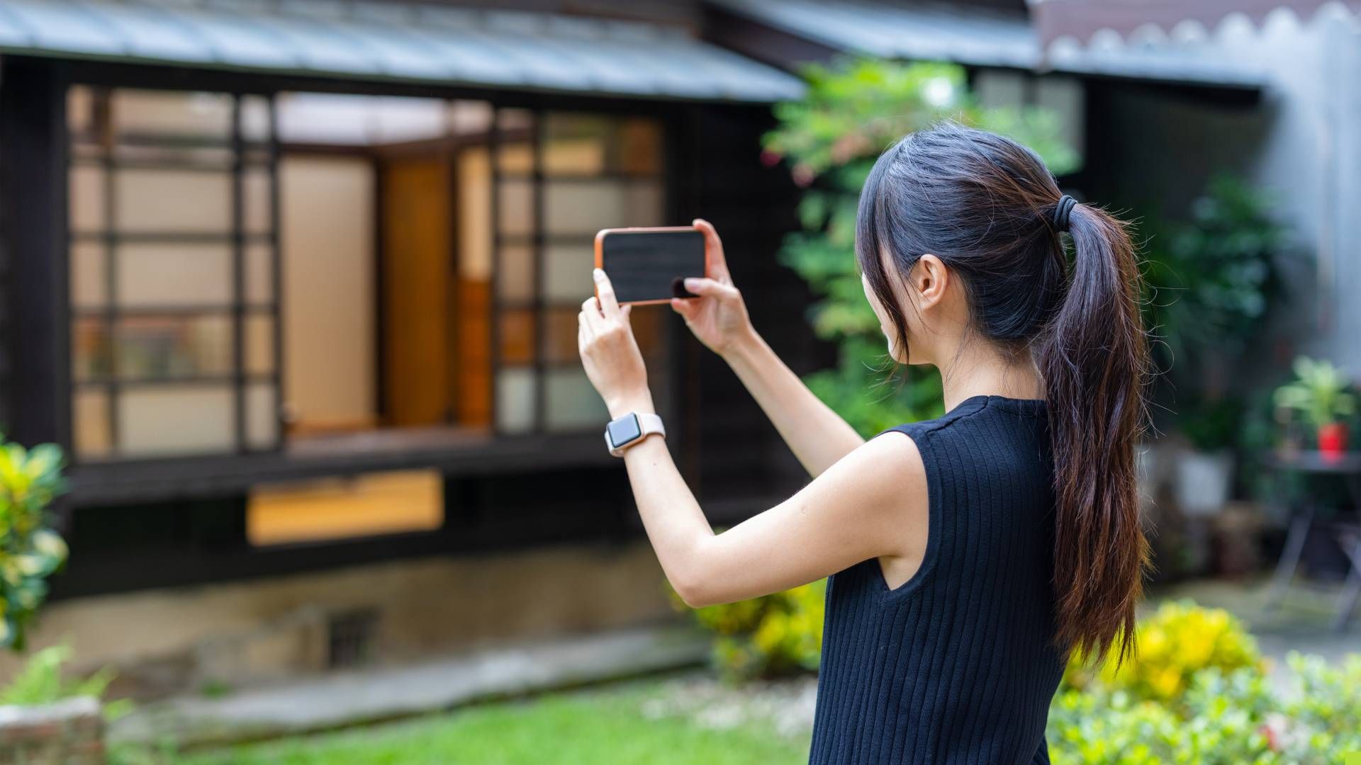 woman taking photo of home