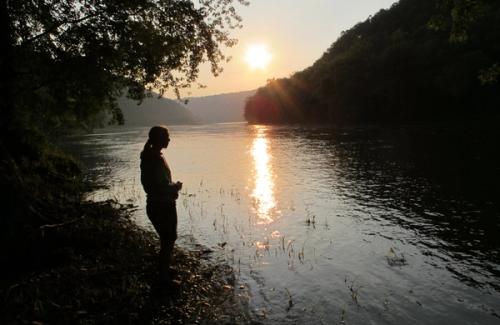 Women by river at sunset