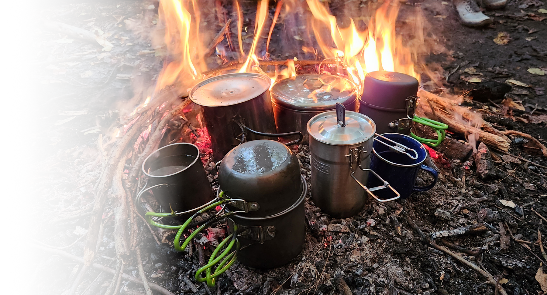 Several metal cups warming in the fire