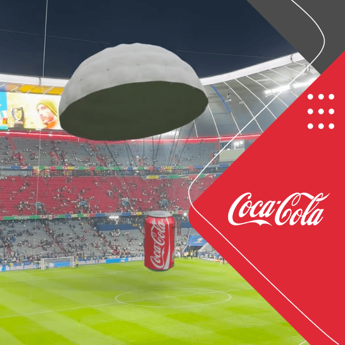 Coca-Cola CGI mit Dose am Fallschirm über einem Fußballstadion