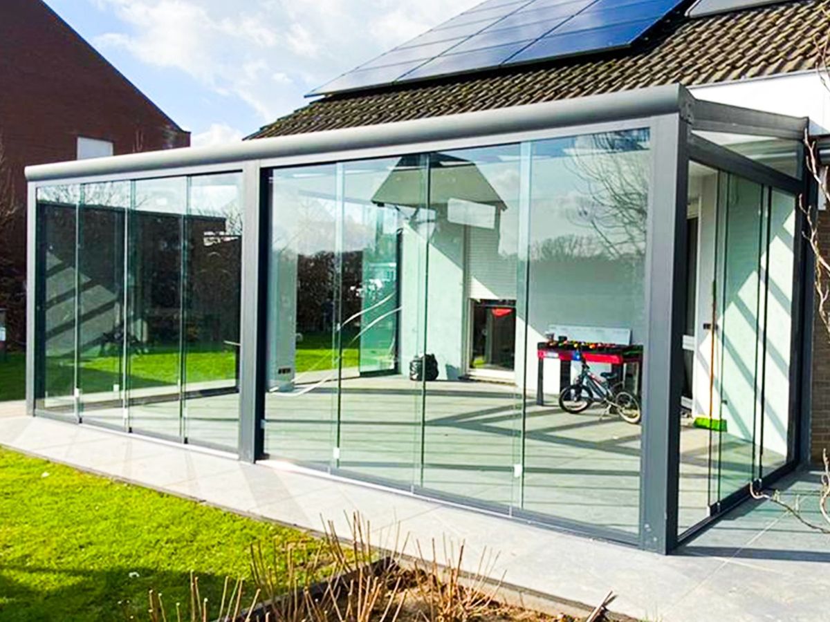 Aluminium overkapping met glazen schuifwanden in de tuin