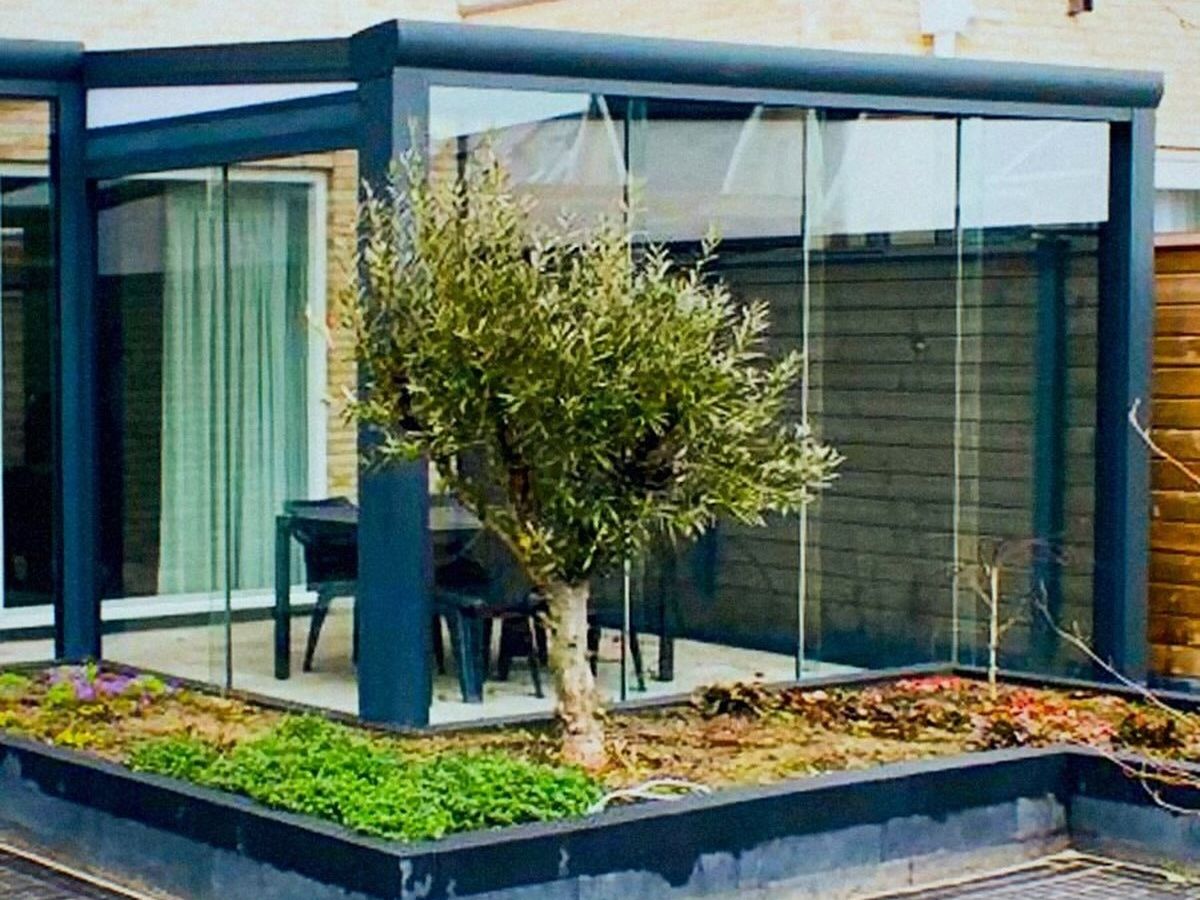 Aluminium veranda op maat met glazen wanden in de tuin