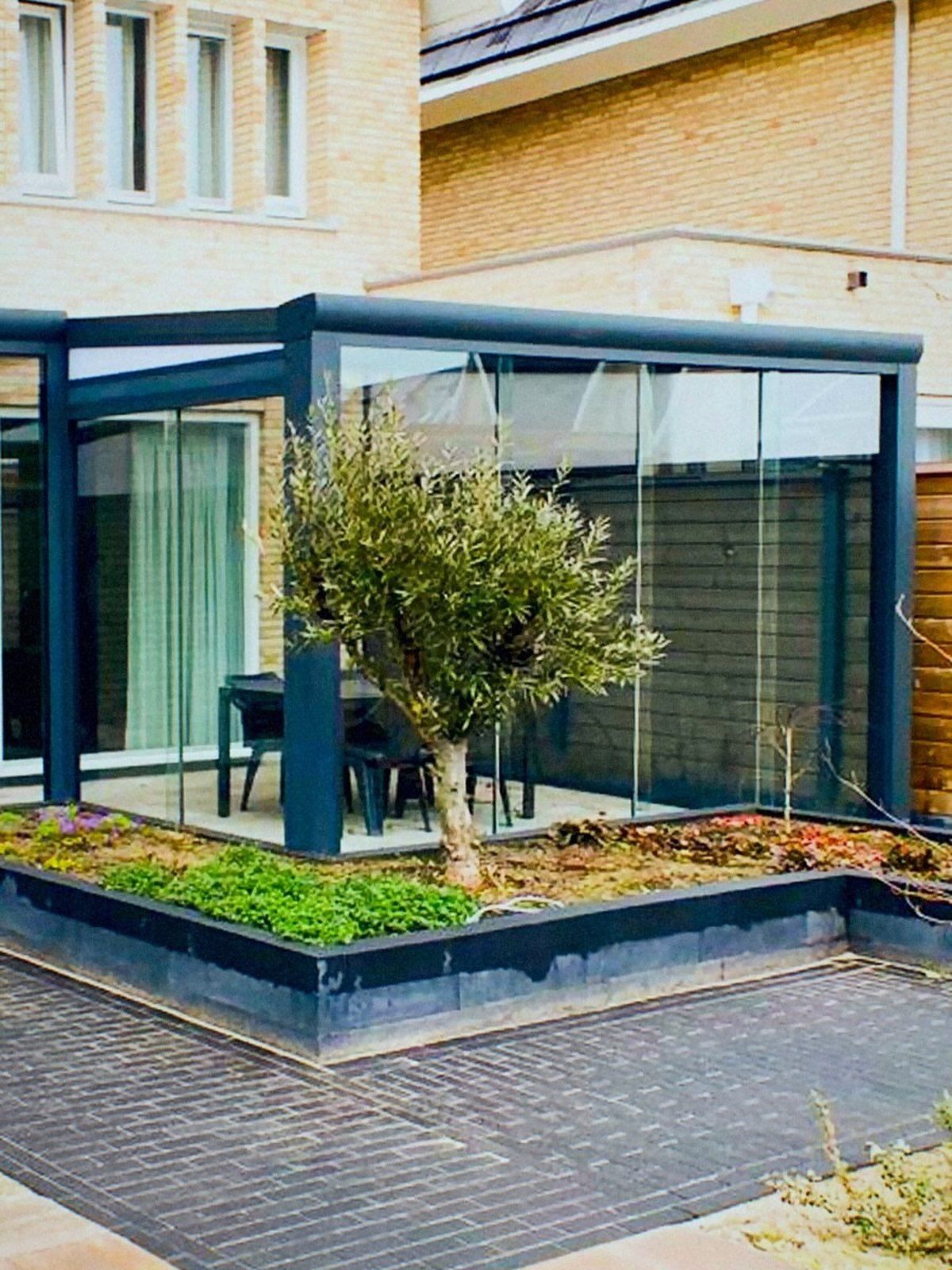Aluminium veranda op maat met glazen wanden in de tuin