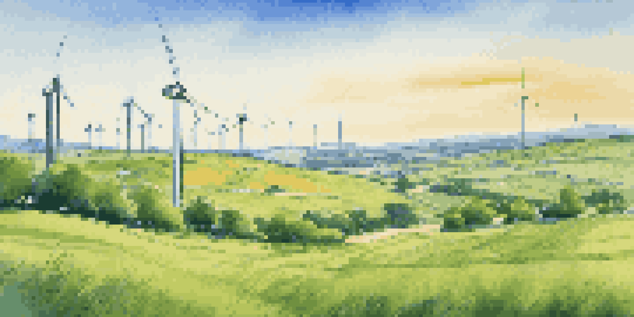 A peaceful landscape showing wind turbines and solar panels in a green field under a bright sky.