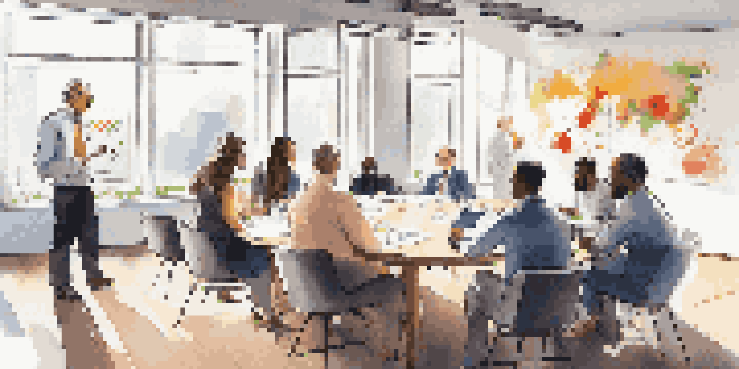 A diverse group of individuals discussing investment strategies in a bright meeting room with laptops and charts.
