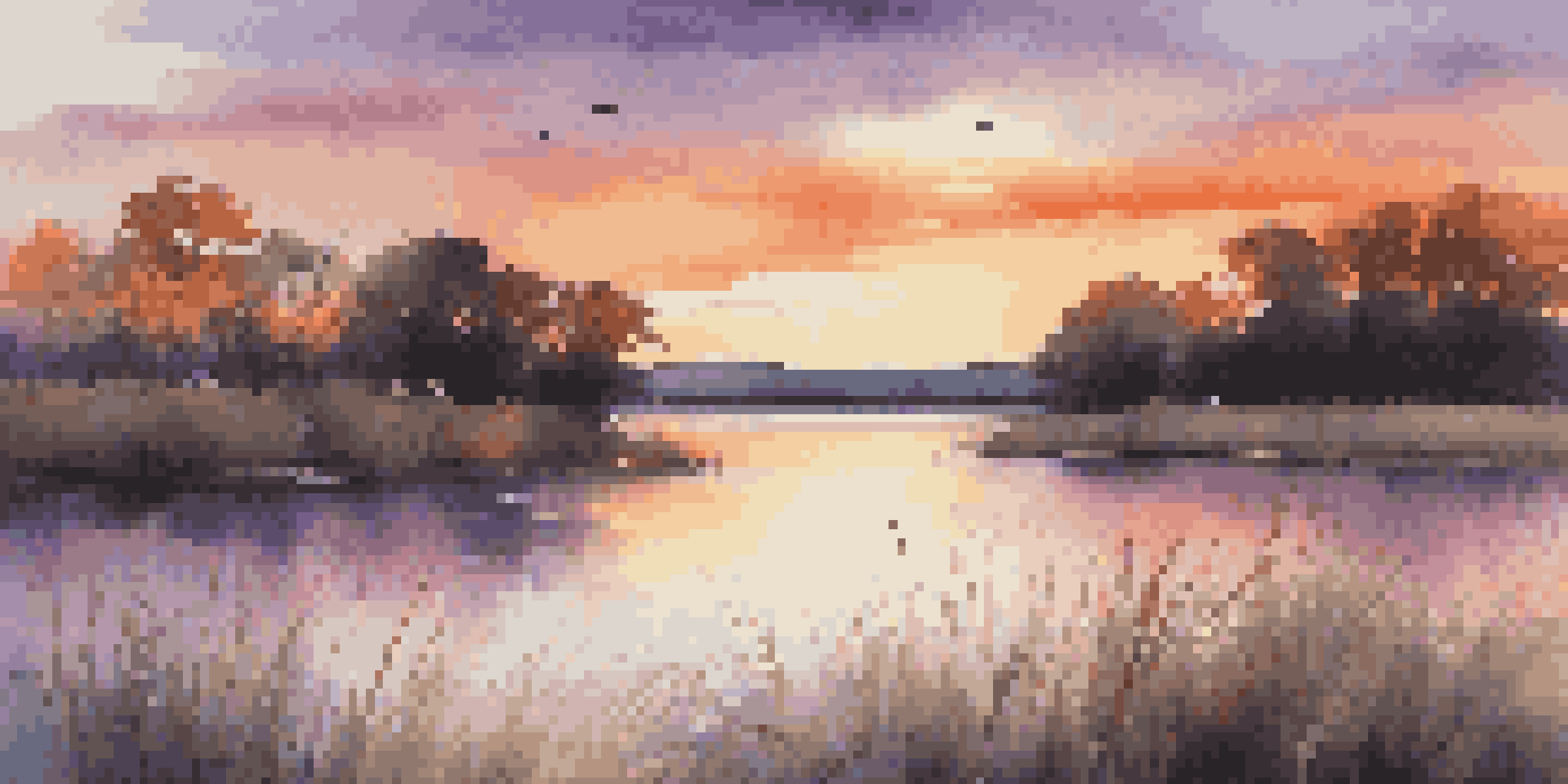 A peaceful sunset over a calm lake with colorful reflections and silhouettes of trees.
