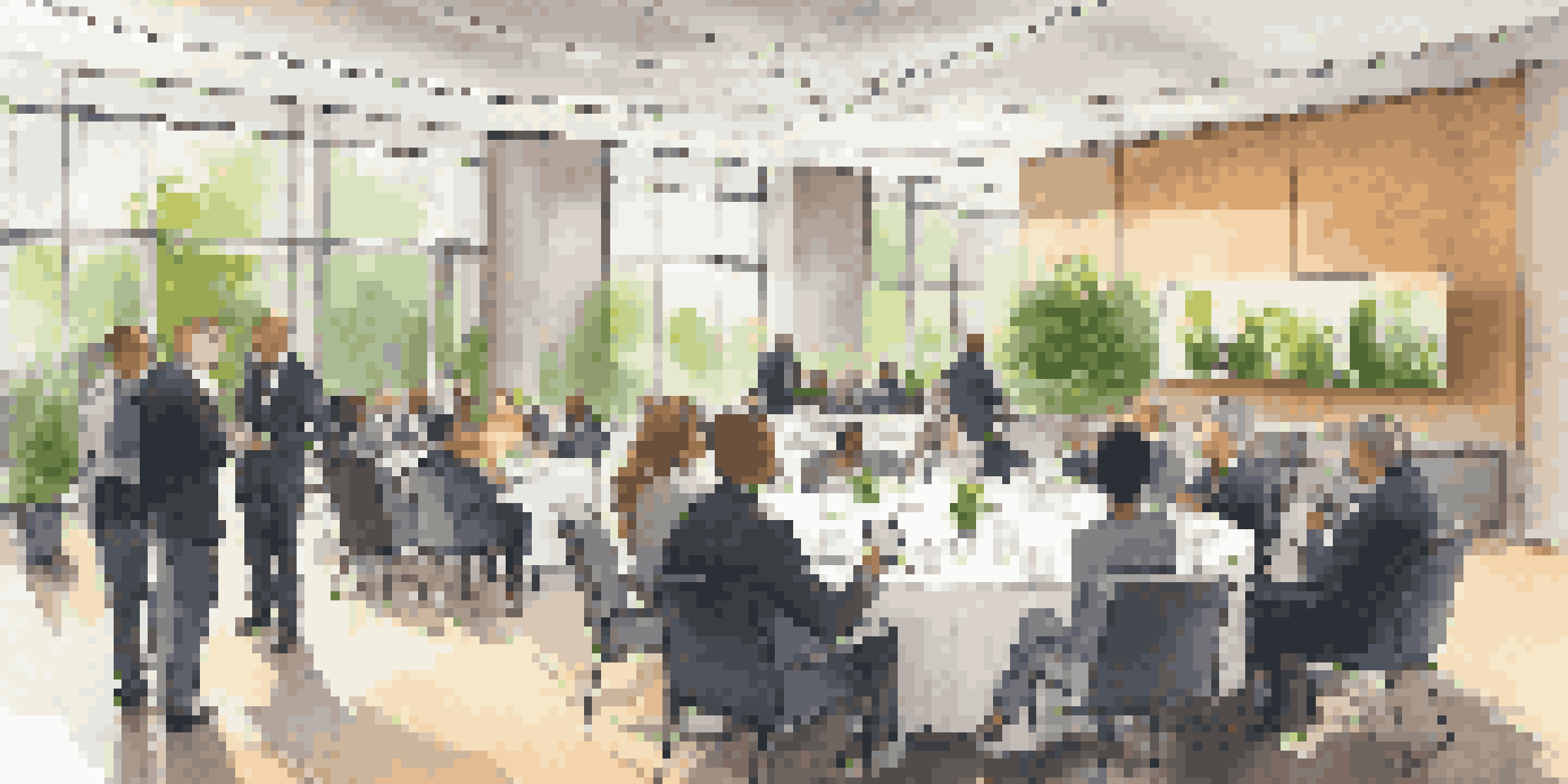 A diverse group of professionals engaged in conversation at a networking event in a modern conference hall.