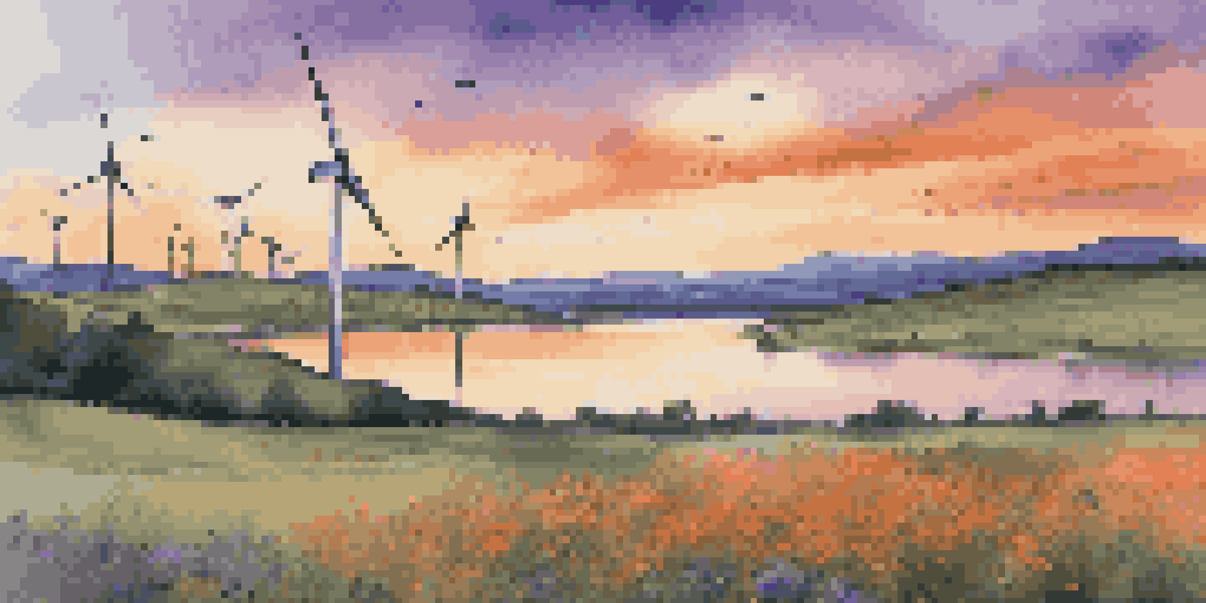 A beautiful sunset over a wind farm with colorful skies and blooming wildflowers in the foreground.