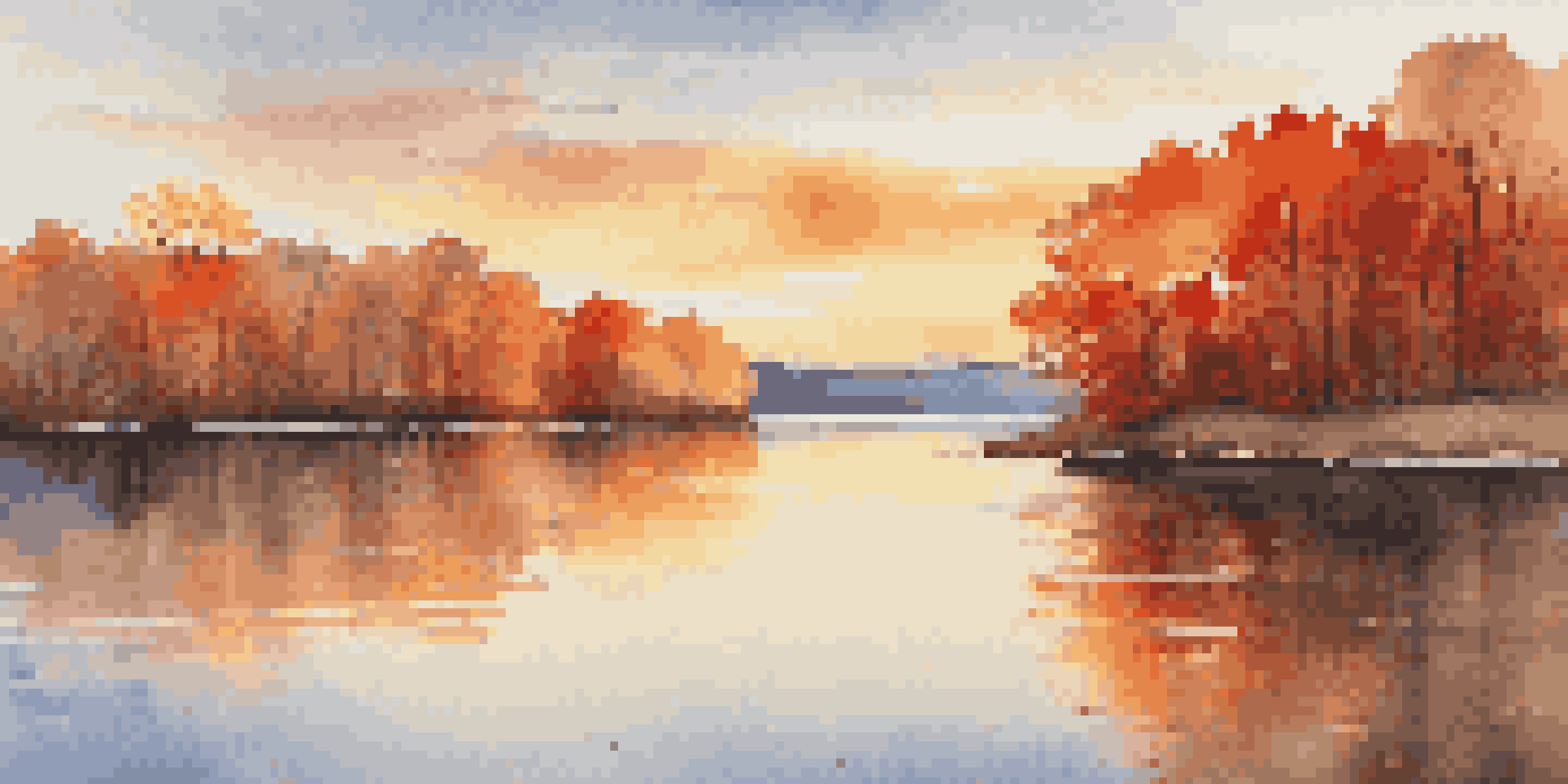 A calm lake surrounded by colorful autumn trees with a sunset casting a golden glow.