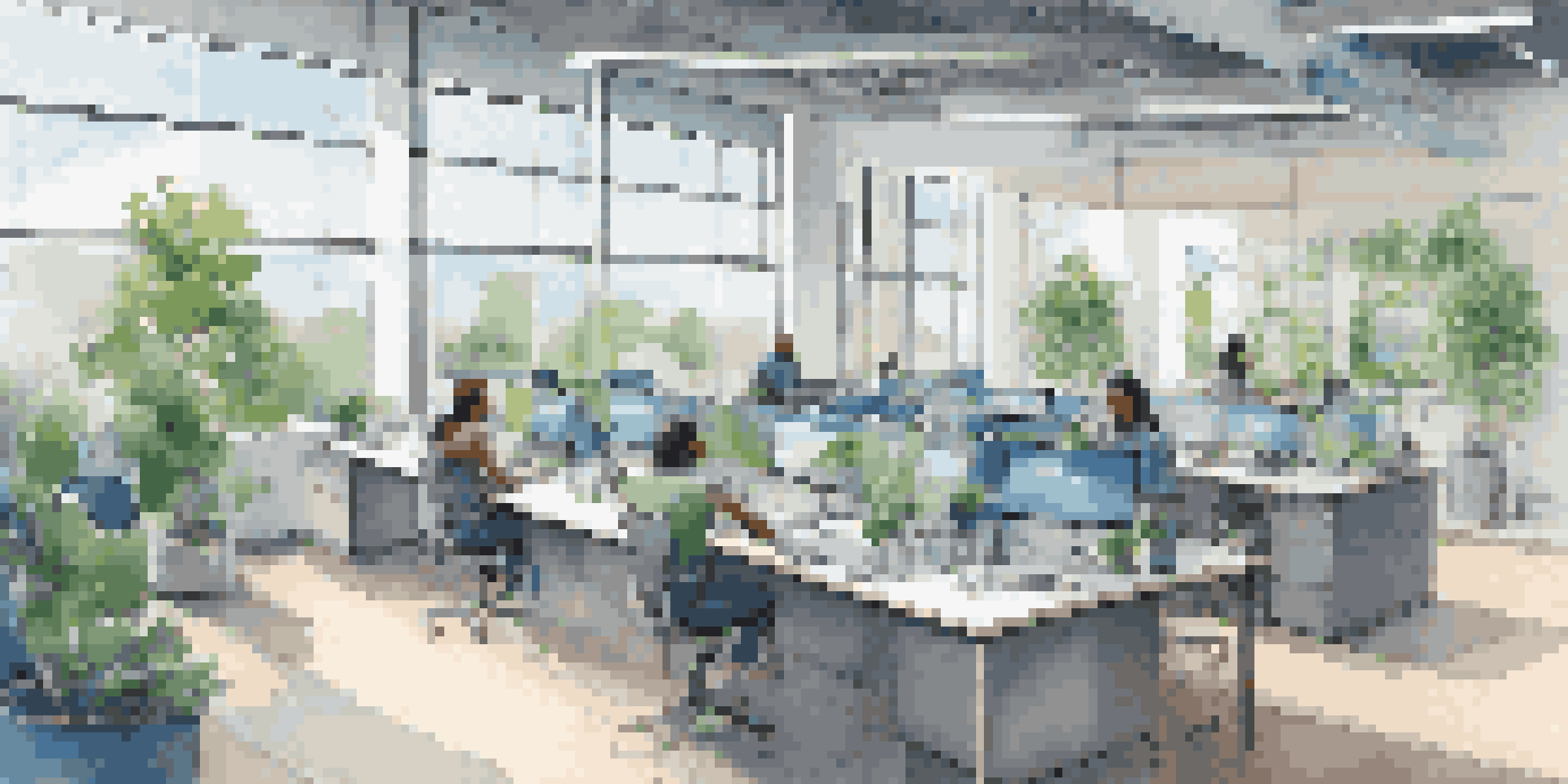 A vibrant tech startup office with diverse employees working together in an open space filled with natural light and plants.