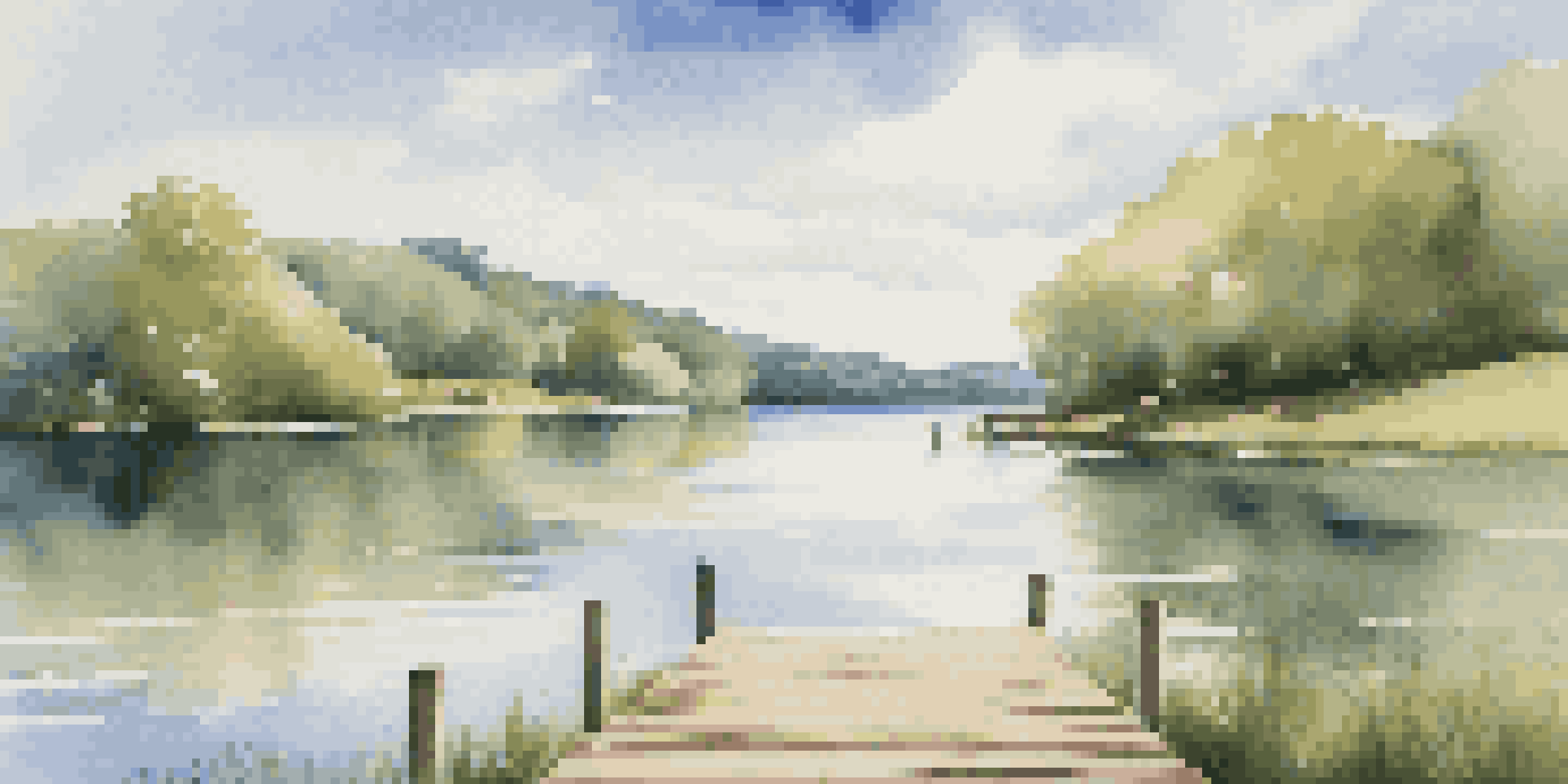 A tranquil lake scene with green hills and a wooden dock under a blue sky.