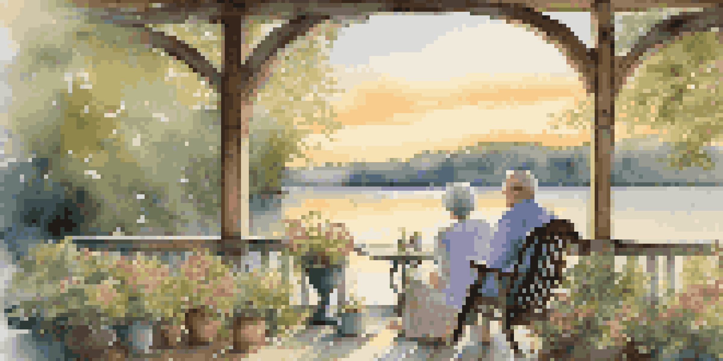 A couple sitting on a porch by a lake at sunset, enjoying tea and surrounded by nature, symbolizing a secure retirement.