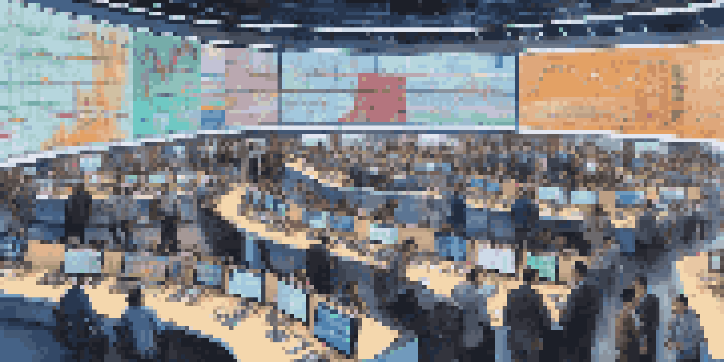 A busy stock trading floor with traders focused on their screens and colorful stock market data displayed.