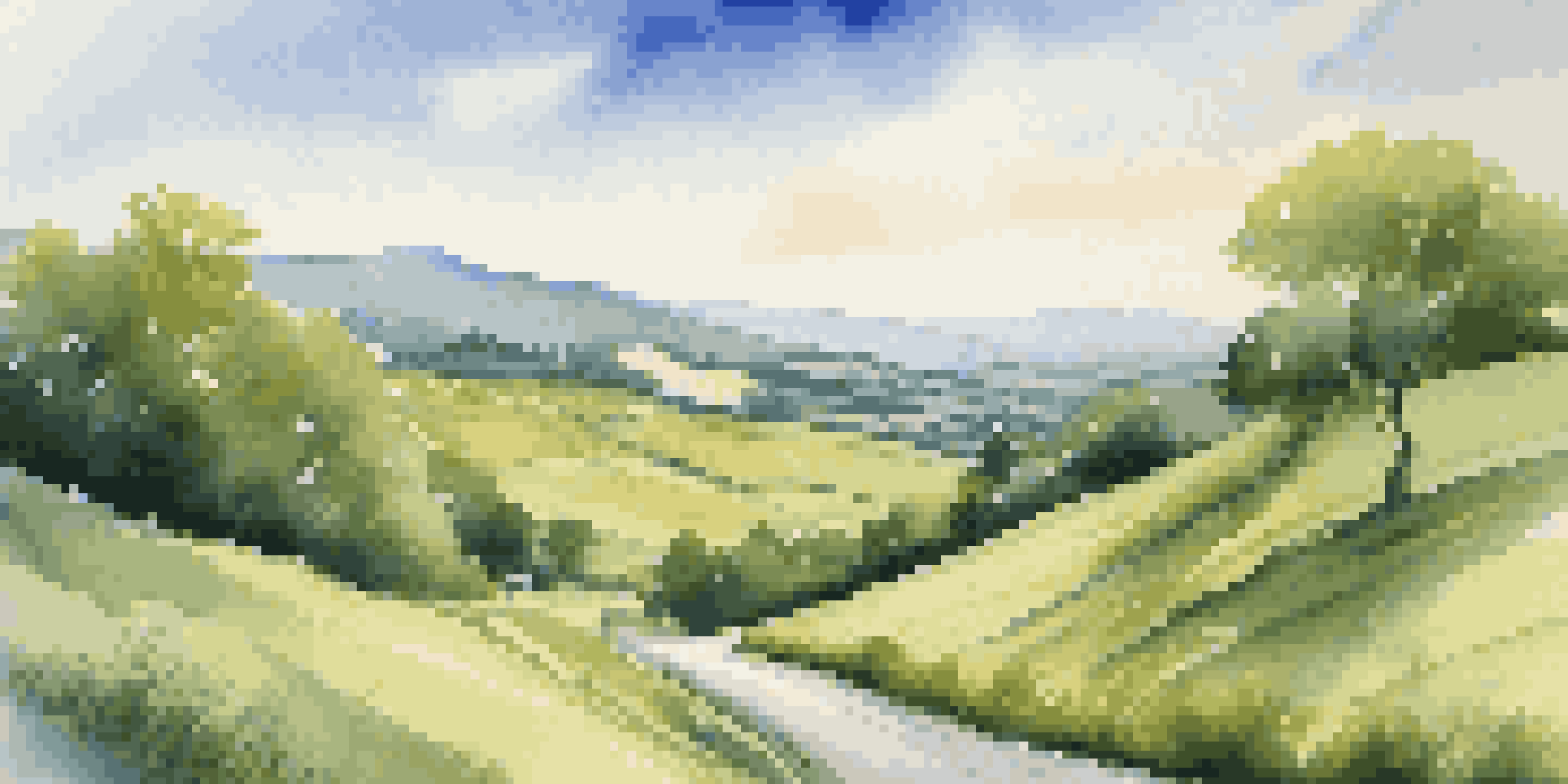 A winding road through a green countryside illustrating the journey of financial planning with bright blue skies and fluffy clouds.