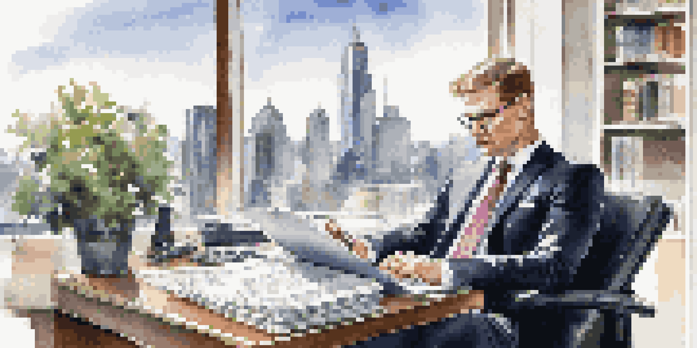 A wealth manager in a modern office setting, reviewing documents on a laptop with a city view outside.