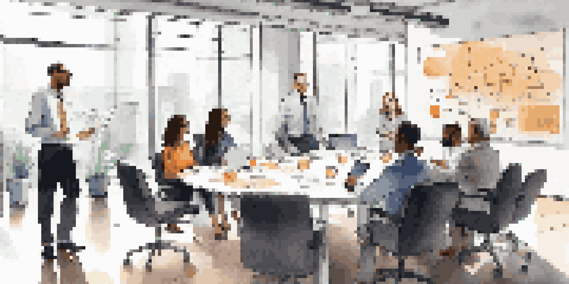 A diverse group of entrepreneurs in a modern office discussing startup strategies around a conference table.