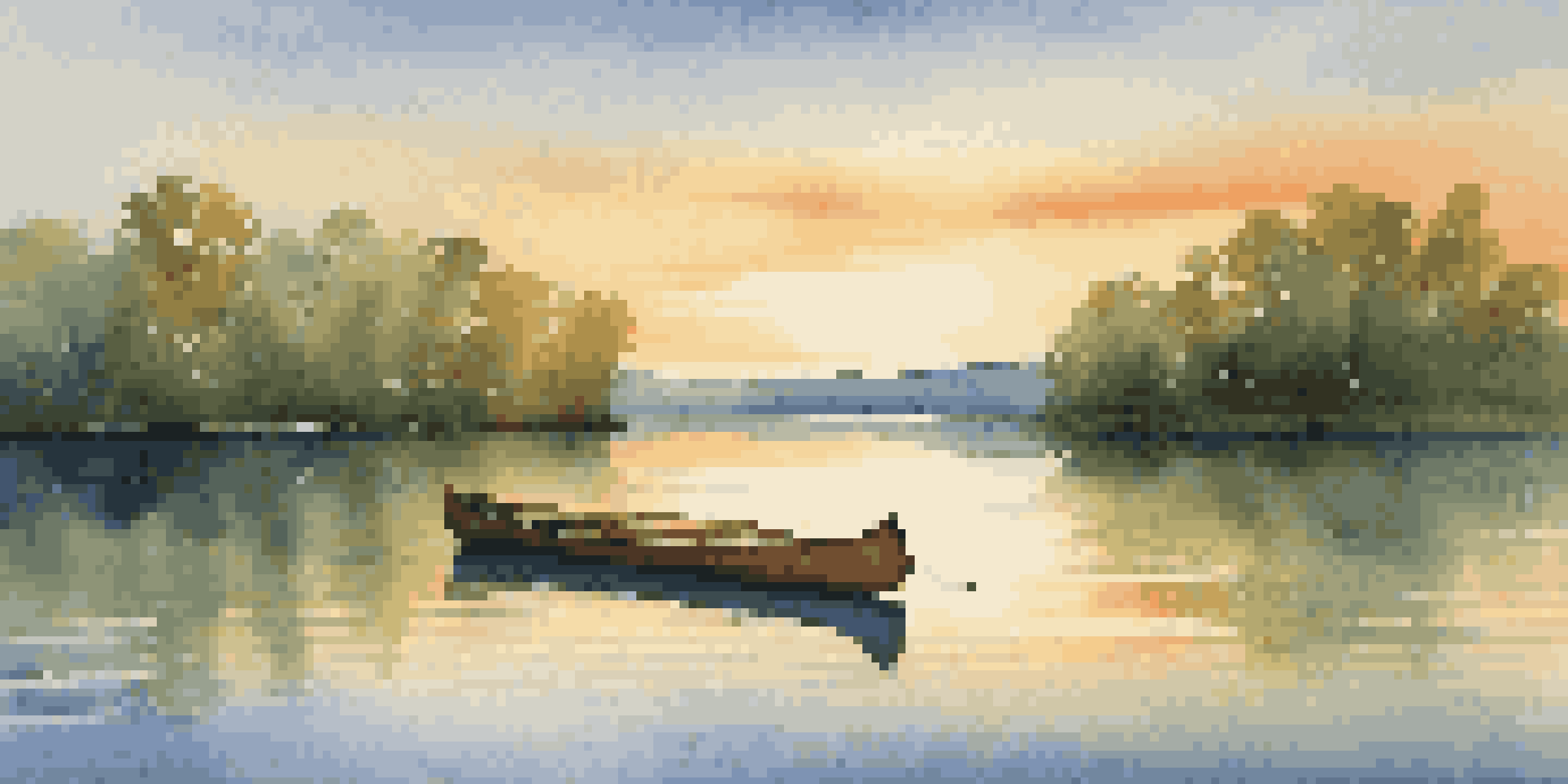 A tranquil lake surrounded by green trees, with a canoe at the shore during sunset.