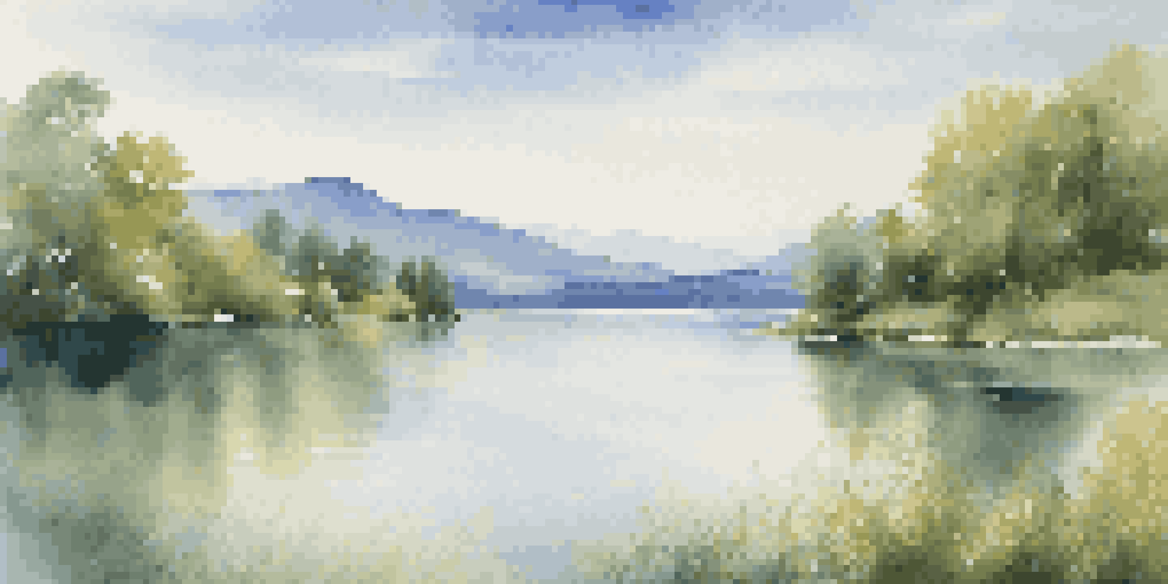 A peaceful lake surrounded by trees and mountains under a blue sky with clouds.