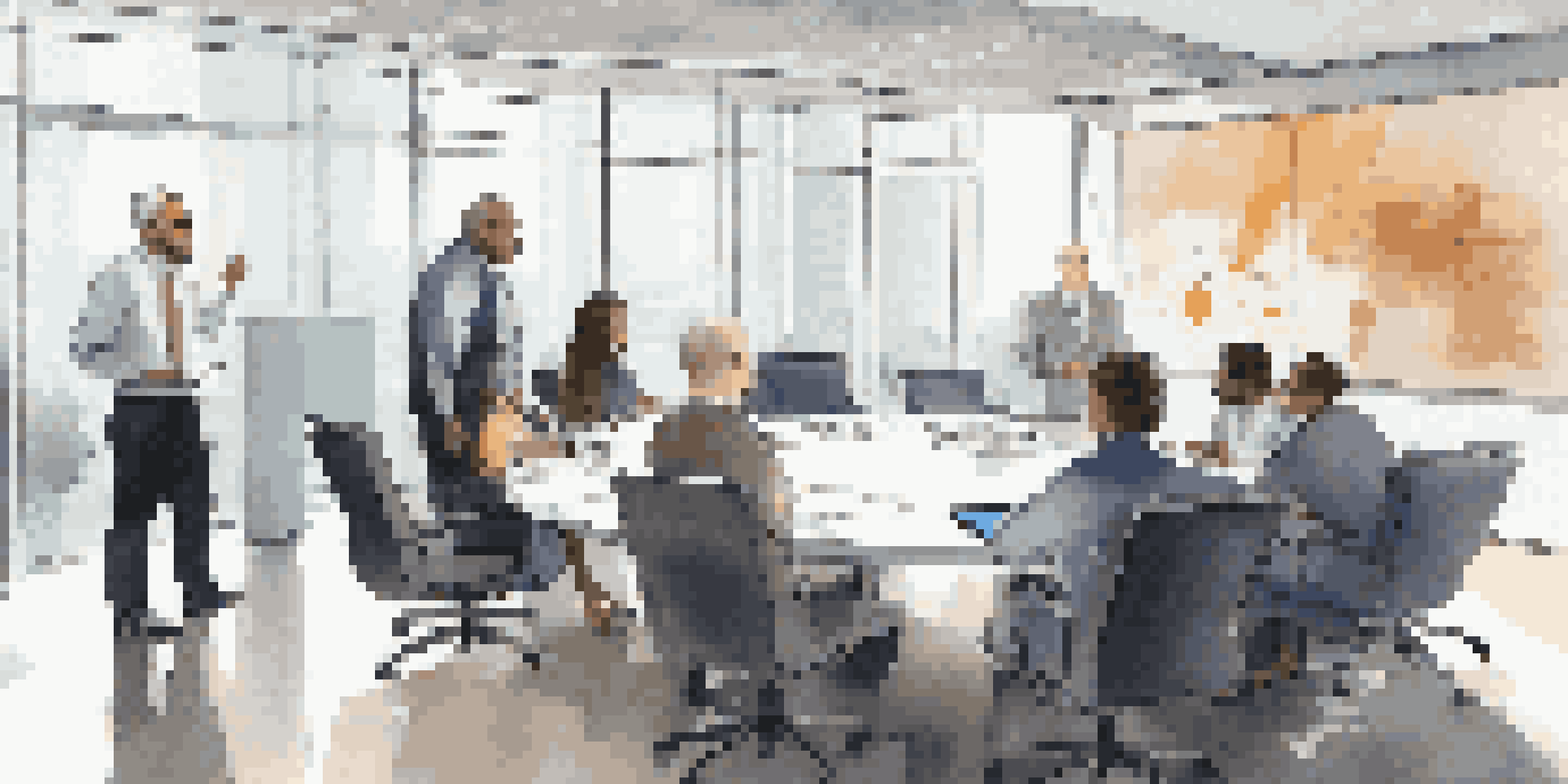A group of diverse compliance officers in a modern office discussing compliance regulations around a conference table.