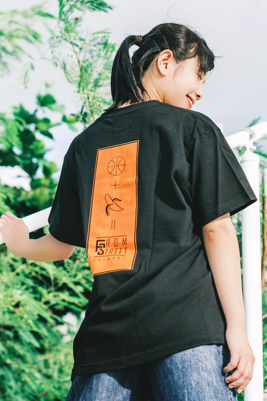 オレンジ色のバスケットボールとバナナのバックプリントが入った黒いFrom StreetのTシャツの着用写真