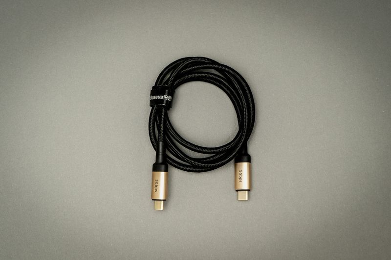 A black USB-C cable lying on a white table