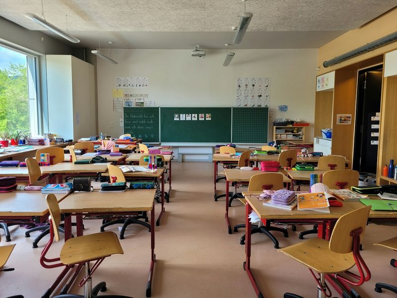 An empty classroom with rows of desks and chairs