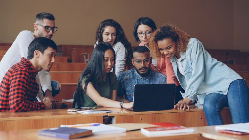 Students studying together around a laptop