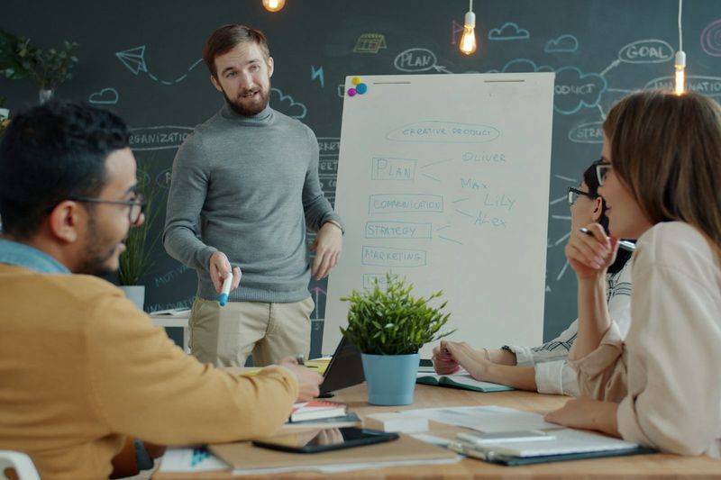 A team discussing a plan in front of a whiteboard