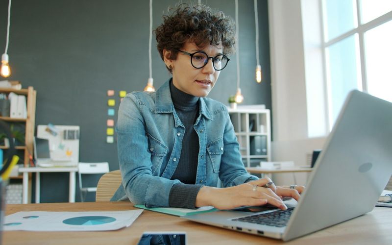 Focused office worker typing on a laptop at a desk