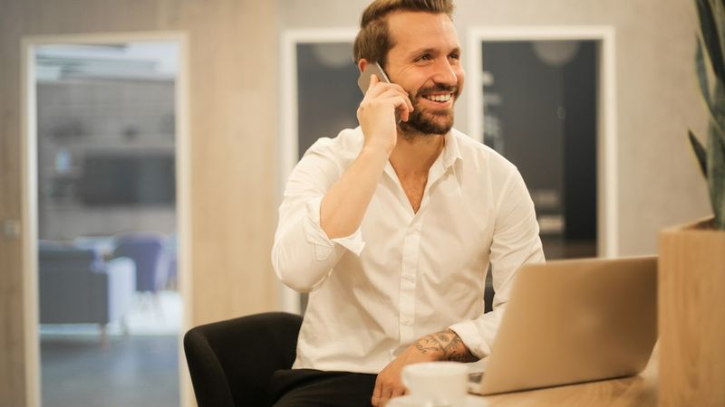 A man sitting in a chair looking at his smartphone