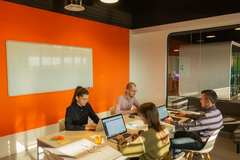 People sitting around a table with open laptops in a meeting
