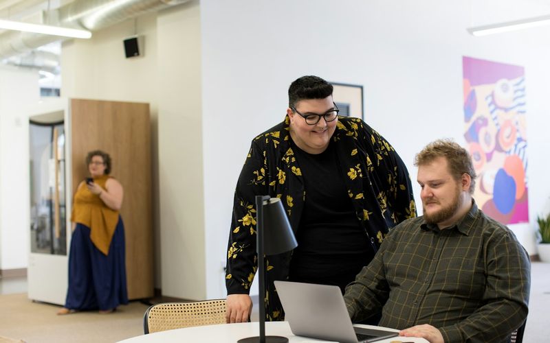 Coworkers working on laptops together in a bright office