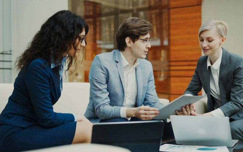 Coworkers discussing documents in a meeting room