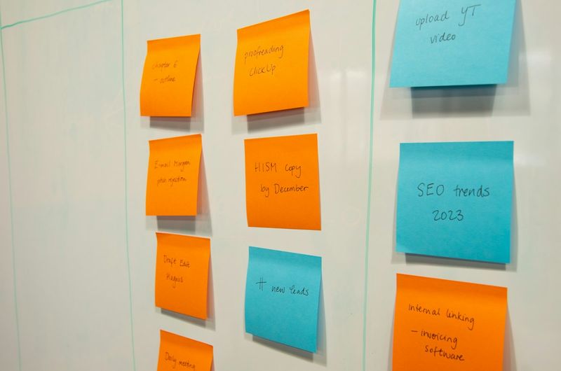 Orange and blue sticky notes arranged like a kanban board on a whiteboard