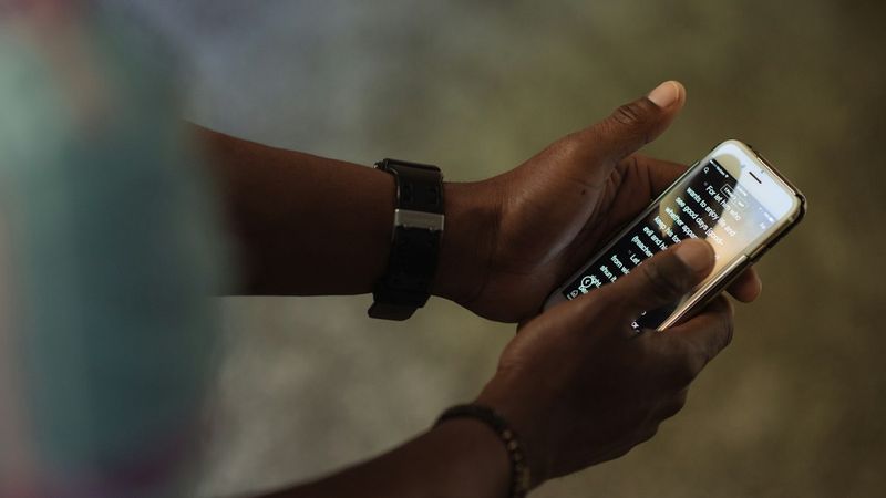 A person holding a smartphone and checking messages