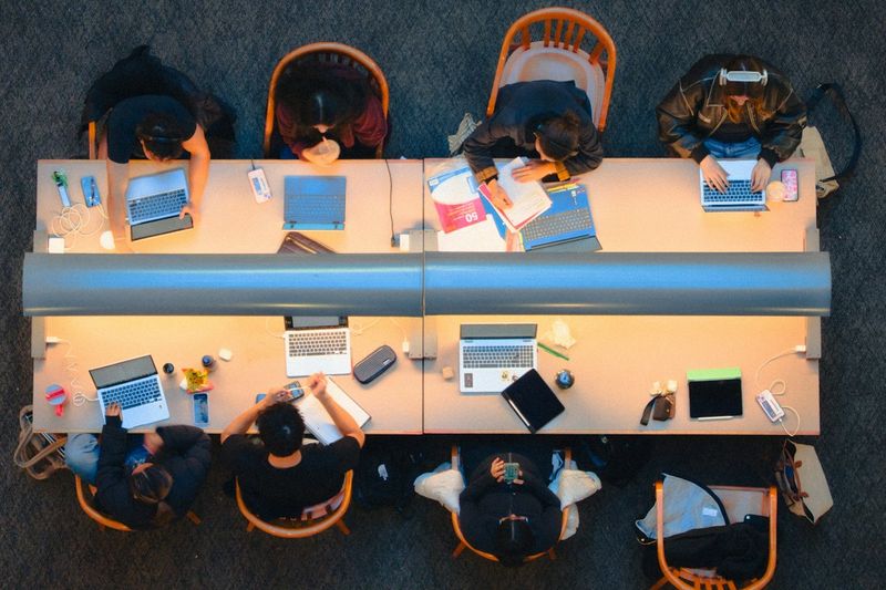 Students studying together at a long table in a library