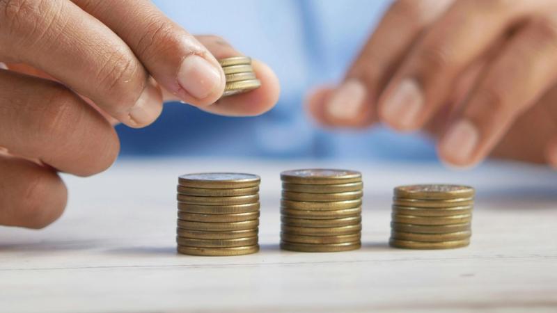 Hands placing coins in 3 piles