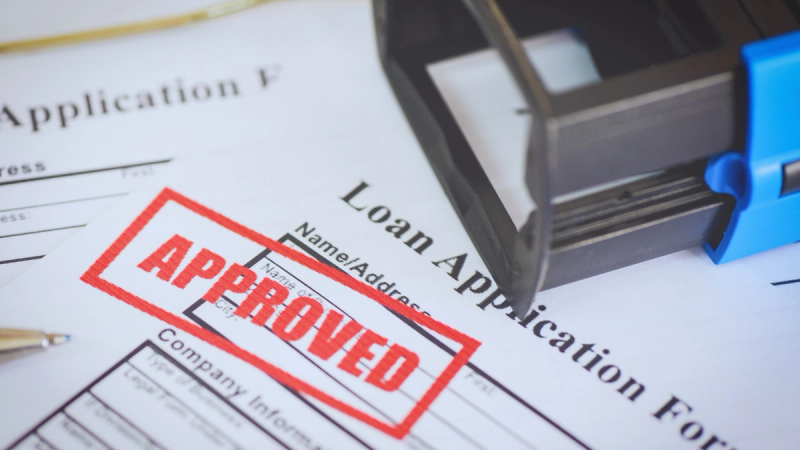 Close-up of a printed Australian SMB loan application form with a prominent red APPROVED stamp.