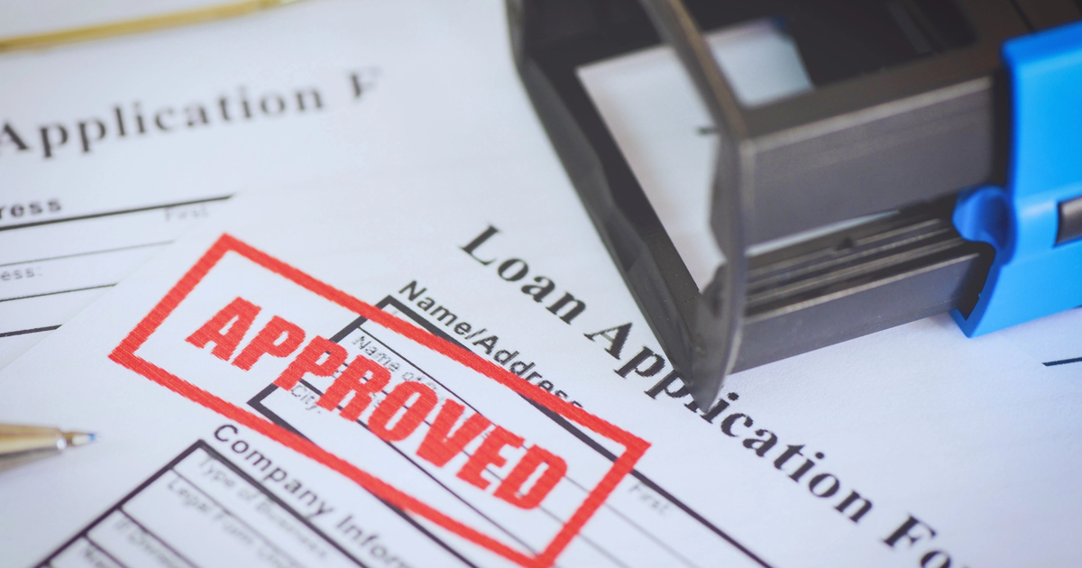 Close-up of a printed Australian SMB loan application form with a prominent red APPROVED stamp.