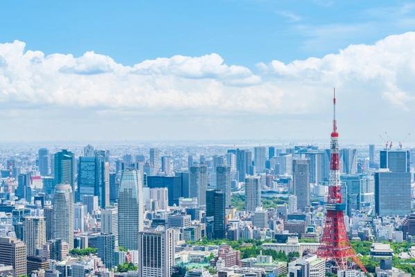 Tokyo skyline with red transmission tower and urban buildings under blue sky