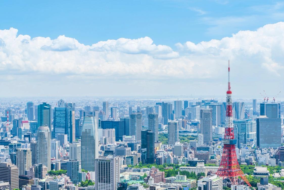Tokyo skyline with red transmission tower and urban buildings under blue sky