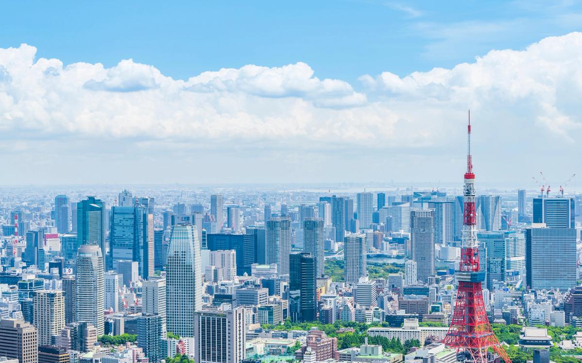 Tokyo skyline with red transmission tower and urban buildings under blue sky