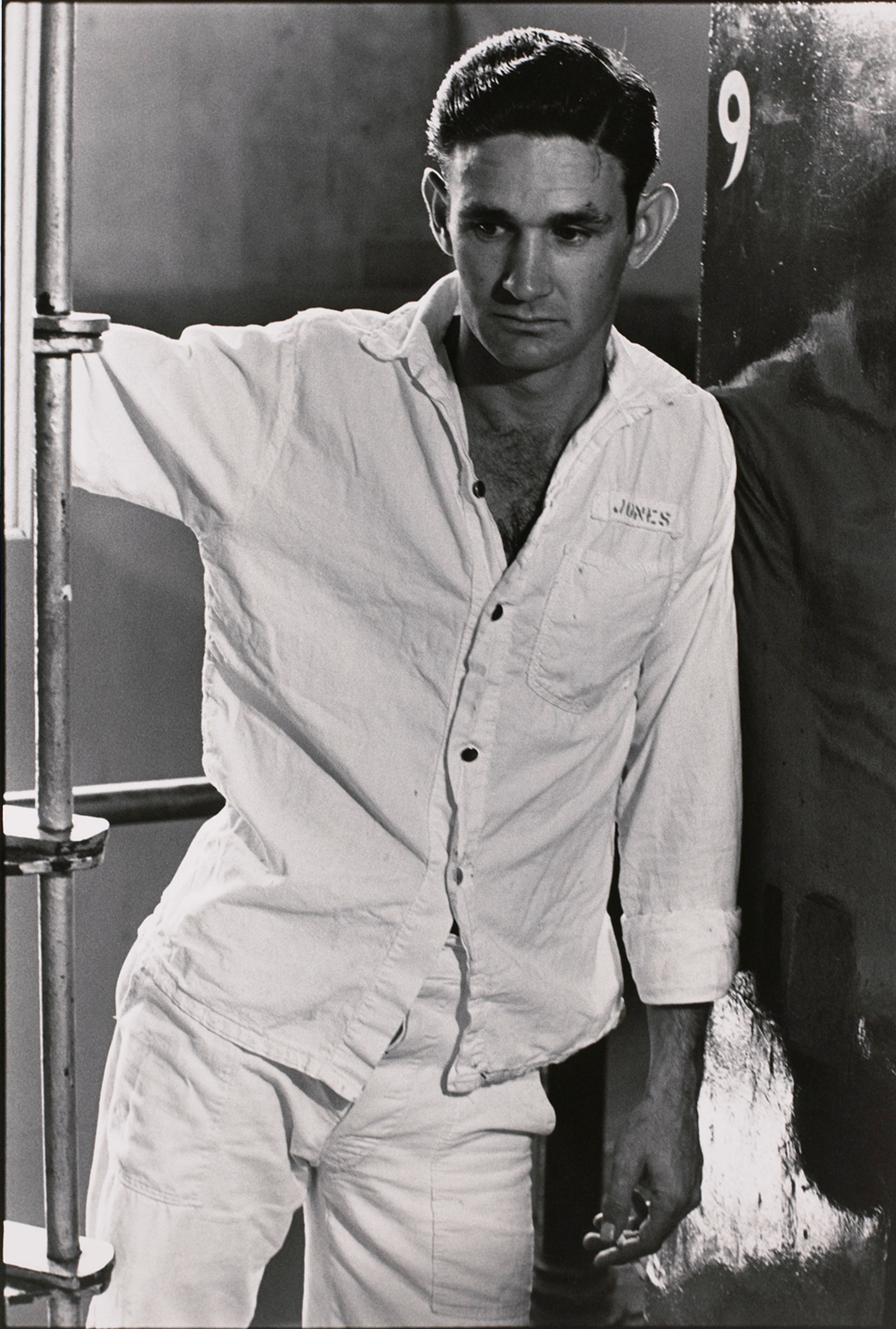 Untitled (Inmate in white shirt, number 9 on adjacent wall)