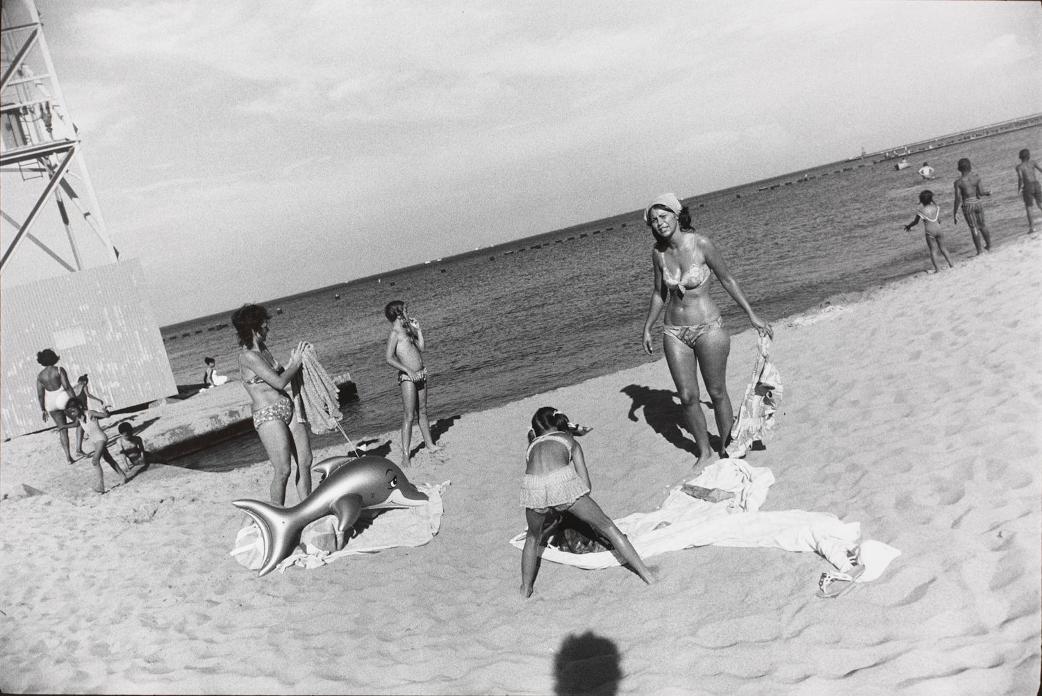 Untitled (Two women on a beach with a child and a blow up dolphin toy)